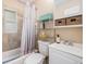 Functional bathroom featuring a tub with shower curtain, tiled walls, and a classic vanity sink at 3640 N Saint Paul St, Denver, CO 80205