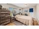 Cozy bedroom with wood-look floors, a rustic dresser, and a queen-size bed beside a bright window at 3640 N Saint Paul St, Denver, CO 80205