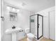 Modern bathroom featuring a glass-enclosed shower, white subway tile, and pedestal sink at 13058 Monaco Way, Thornton, CO 80602