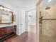 Bathroom featuring a dark vanity with dual sinks and a large mirror at 13058 Monaco Way, Thornton, CO 80602