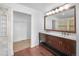 This bathroom has a double sink vanity with a dark wood cabinet and an attached walk-in closet at 13058 Monaco Way, Thornton, CO 80602