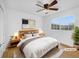 Cozy bedroom featuring a ceiling fan, large window, and wood-look flooring at 13058 Monaco Way, Thornton, CO 80602