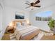 A bedroom with a ceiling fan, large window, and light wood furniture creates a serene space at 13058 Monaco Way, Thornton, CO 80602