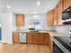 Kitchen showcasing wood cabinets, stainless steel appliances, and a window overlooking the yard at 13058 Monaco Way, Thornton, CO 80602