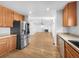 Spacious kitchen flowing into a living room with fireplace, wood floors and stainless steel appliances at 13058 Monaco Way, Thornton, CO 80602