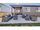 Inviting covered backyard patio with comfortable seating and a fire pit, ideal for outdoor entertaining at 13437 Waterthrush St, Parker, CO 80134