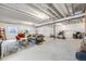 Partially finished basement with seating, exercise equipment, concrete flooring, and exposed ceiling at 13437 Waterthrush St, Parker, CO 80134