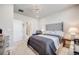 Bright bedroom featuring a luxurious bed, a modern light fixture, and an adjacent doorway to the bathroom at 13437 Waterthrush St, Parker, CO 80134