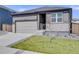 Single-Gathering home with a two-car garage, green lawn, and stylish gray exterior, under a clear blue sky at 13437 Waterthrush St, Parker, CO 80134