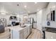 Stylish kitchen with white cabinets, stainless steel appliances, and an island with seating open to the living room at 13437 Waterthrush St, Parker, CO 80134