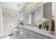 Traditional bathroom with white cabinets, gold fixtures, and a lighted mirror above a white tiled vanity at 5390 S Boston St, Greenwood Village, CO 80111
