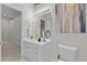 Bright bathroom featuring white cabinets, gold hardware, and a decorative painting at 5390 S Boston St, Greenwood Village, CO 80111
