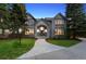 Charming home with stone facade, arched entryway, and manicured front lawn with mature trees at 5390 S Boston St, Greenwood Village, CO 80111
