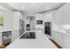 Bright kitchen features white cabinets, countertops, island with cooktop, stainless appliances, and modern backsplash at 5390 S Boston St, Greenwood Village, CO 80111