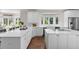 Modern kitchen with custom white cabinetry, large island, stainless steel appliances, and bright windows at 5390 S Boston St, Greenwood Village, CO 80111
