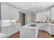 Bright kitchen features white cabinets, countertops, island with cooktop, and modern backsplash at 5390 S Boston St, Greenwood Village, CO 80111
