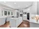 Bright kitchen features white cabinets, countertops, island with cooktop, stainless appliances, and hardwood flooring at 5390 S Boston St, Greenwood Village, CO 80111