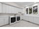 Bright laundry room features new washer and dryer, utility sink, and generous counter space at 5390 S Boston St, Greenwood Village, CO 80111