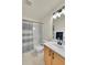 Bathroom featuring a shower-tub combo with stylish curtain, vanity with storage and modern lighting at 16773 W 61St Ln, Arvada, CO 80403