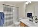 Functional bathroom featuring a shower-tub combo with stylish curtain, vanity with storage and light at 16773 W 61St Ln, Arvada, CO 80403
