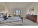 Bright bedroom with a large window, dresser, patterned bedding and carpeted floors at 16773 W 61St Ln, Arvada, CO 80403