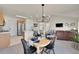 Eat-in kitchen open to the living room, dining area with stylish chandelier and modern decor at 16773 W 61St Ln, Arvada, CO 80403