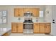 Kitchen featuring stainless steel appliances and natural wood cabinets at 16773 W 61St Ln, Arvada, CO 80403