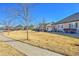 View of a home from the street with a well-kept lawn and mature trees at 16773 W 61St Ln, Arvada, CO 80403