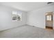 A bright bedroom with neutral carpet, large window providing views and adjacent door at 1366 Penner Dr, Erie, CO 80026