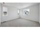 A bright bedroom with neutral carpet, and two large windows providing light at 1366 Penner Dr, Erie, CO 80026