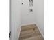 A bright laundry room with wood-look vinyl flooring and modern dryer hookups at 1366 Penner Dr, Erie, CO 80026