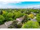 Aerial view showcasing a tree-lined neighborhood with a city skyline in the distance at 9540 E Grand Pl, Greenwood Village, CO 80111