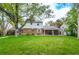 Spacious backyard with lush green lawn, mature tree, and a covered patio area, perfect for outdoor entertaining at 9540 E Grand Pl, Greenwood Village, CO 80111