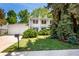 Charming two-story home with white exterior, well-manicured lawn, mature trees, and inviting curb appeal at 9540 E Grand Pl, Greenwood Village, CO 80111