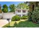 Charming two-story home with white exterior, well-manicured lawn, mature trees, and inviting curb appeal at 9540 E Grand Pl, Greenwood Village, CO 80111