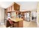 Eat-in kitchen features wood cabinets, island with bar seating, and stainless steel appliances at 9540 E Grand Pl, Greenwood Village, CO 80111