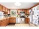 A kitchen with wood cabinets, laminate countertops, stainless steel appliances, and neutral flooring at 9540 E Grand Pl, Greenwood Village, CO 80111