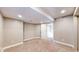 Carpeted basement area with potential for customization, featuring an adjacent doorway at 15926 Butterwort Cir, Parker, CO 80134