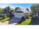 Light blue home featuring well-manicured lawn, mature trees and a two-car garage at 15926 Butterwort Cir, Parker, CO 80134