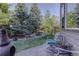 Tranquil backyard featuring mature trees, lush grass, and a charming water feature at 10914 W Coco Pl, Littleton, CO 80127