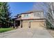 Two-story home with stone accents and a two-car garage on a sunny day at 10914 W Coco Pl, Littleton, CO 80127