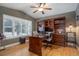 Spacious home office with custom built-ins, hardwood floors, and a ceiling fan at 10914 W Coco Pl, Littleton, CO 80127