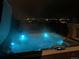 Nighttime view of illuminated hot tub with neighborhood lights in background at 10914 W Coco Pl, Littleton, CO 80127