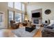 Bright living room with a stone fireplace, hardwood floors, and large windows at 10914 W Coco Pl, Littleton, CO 80127