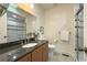 Well-lit bathroom with a granite countertop vanity and tiled shower at 1836 S Grant St, Denver, CO 80210