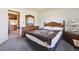 A carpeted bedroom shows bed, side table, dresser with mirror, and hallway at 13225 Grove Way, Broomfield, CO 80020