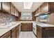 Well-lit kitchen featuring wood cabinetry, brick backsplash, modern appliances and sleek countertops at 13225 Grove Way, Broomfield, CO 80020