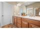 Bathroom featuring a double sink vanity with wood cabinets and a large mirror at 15414 Xenia Ct, Thornton, CO 80602