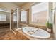 Beautiful primary bathroom featuring a glass shower, soaking tub, and large window at 15414 Xenia Ct, Thornton, CO 80602