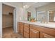 Bathroom featuring a double sink vanity with wood cabinets and a large mirror at 15414 Xenia Ct, Thornton, CO 80602